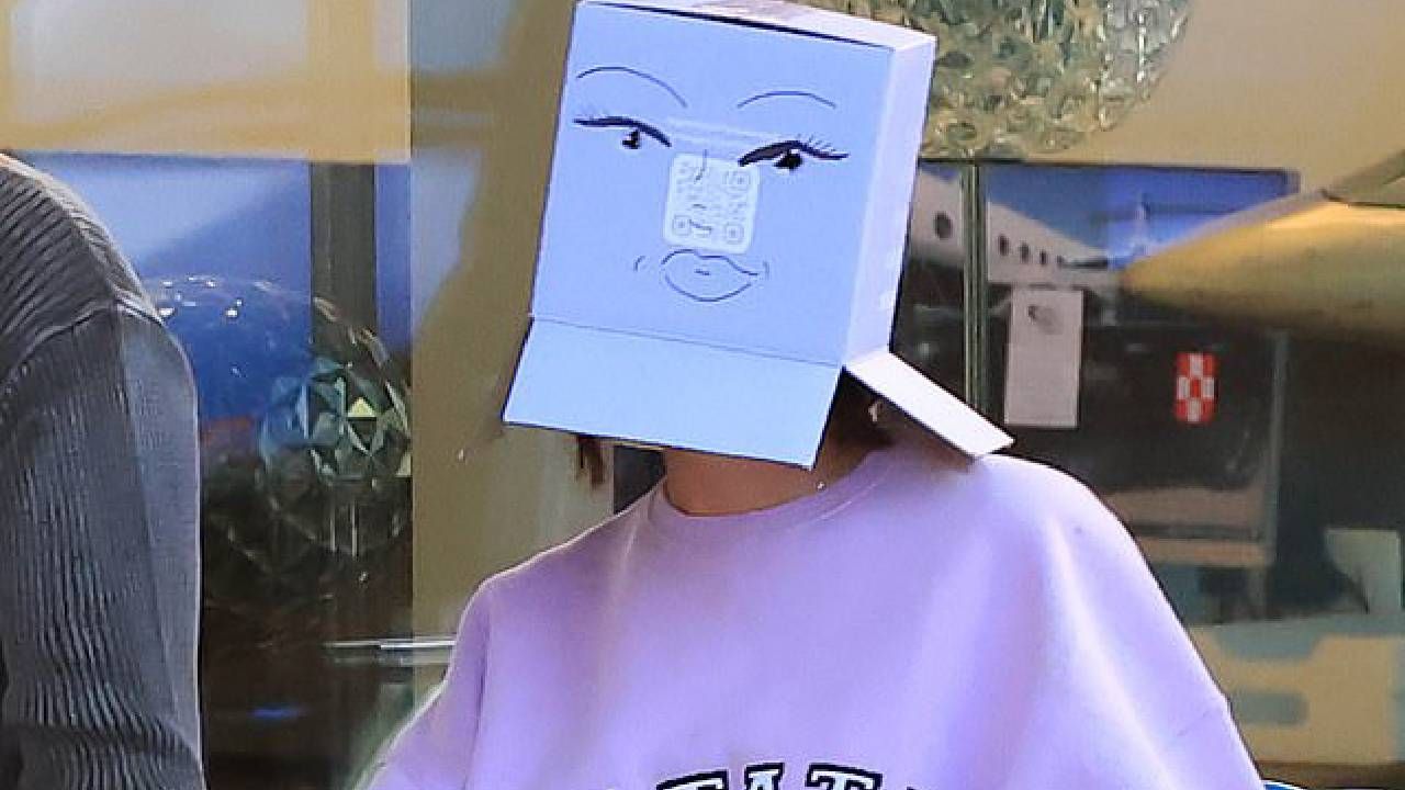 Oculta su rostro con una caja para el evento 